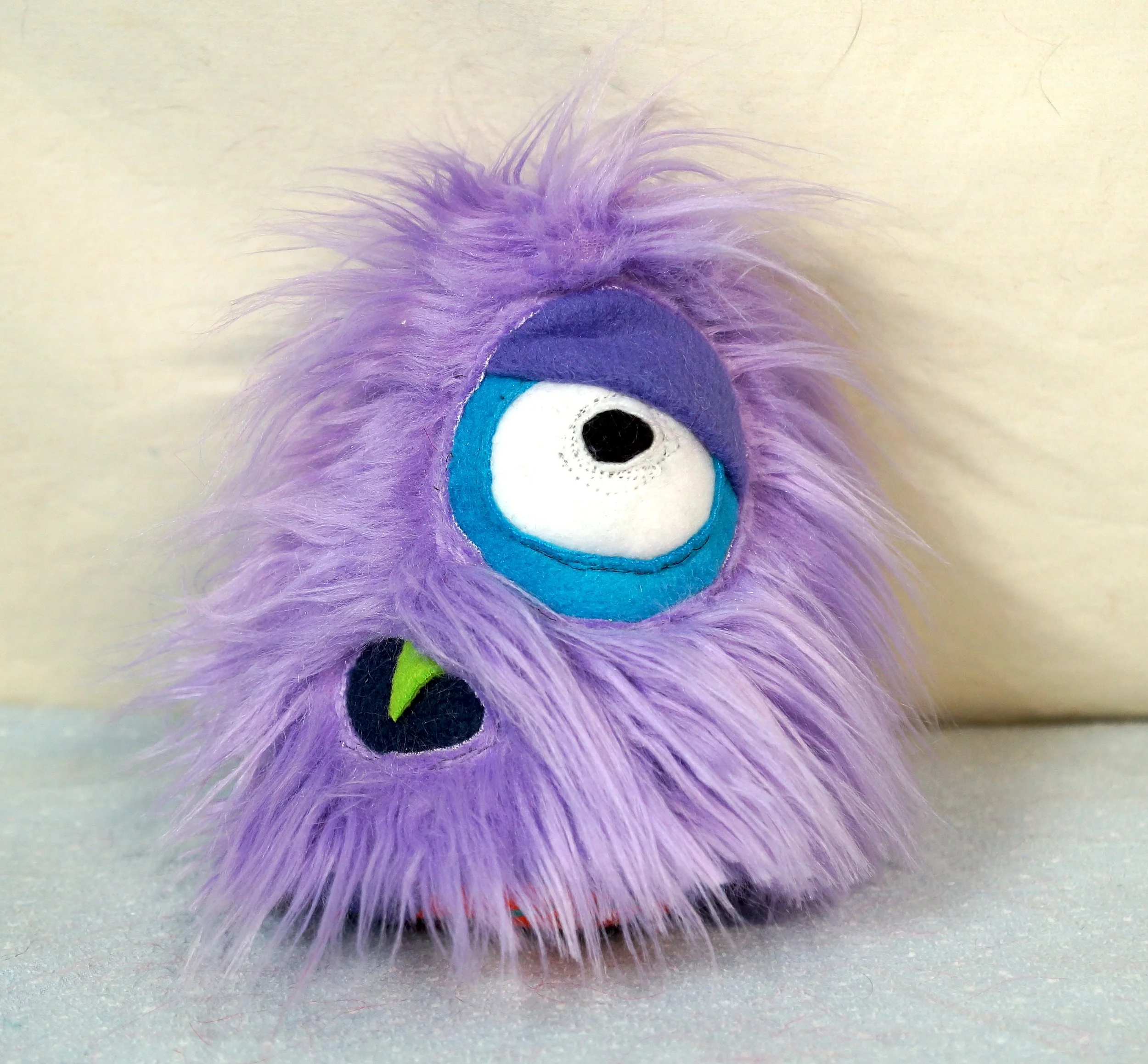 SMALL LIGHT PURPLE MONSTER WITH ONE SLEEPY EYE, MOUTH — TIM